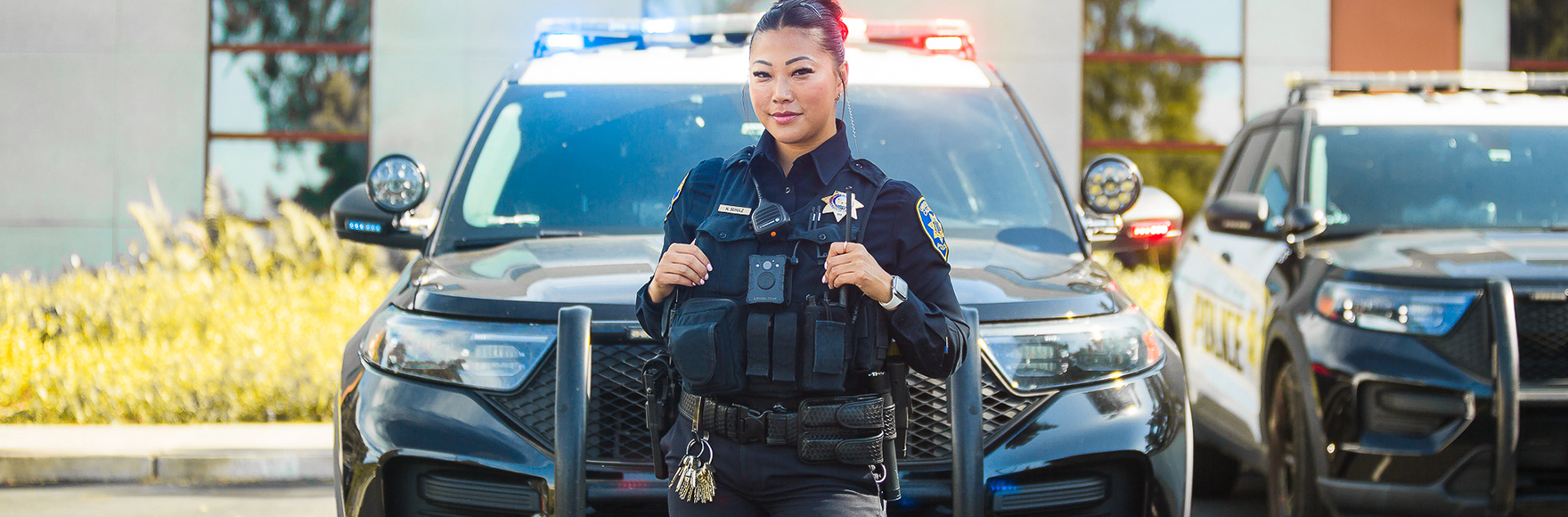 Officer Schulz smiling in front of police car