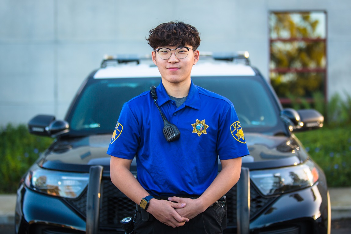 A photo of a smiling female CSO in front of a police car